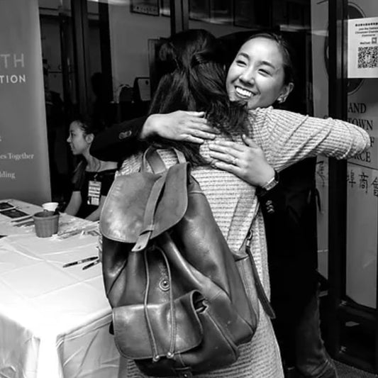 A black and white photo of two women hugging at an aapi women lead event